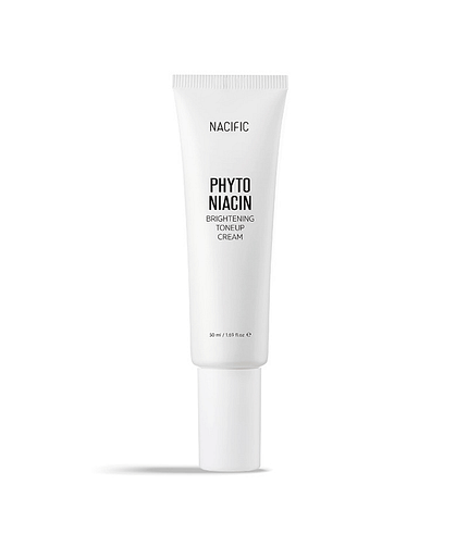 NACIFIC Phyto Niacin Brightening Essence bottle with fresh leaves and a lemon on a marble surface.