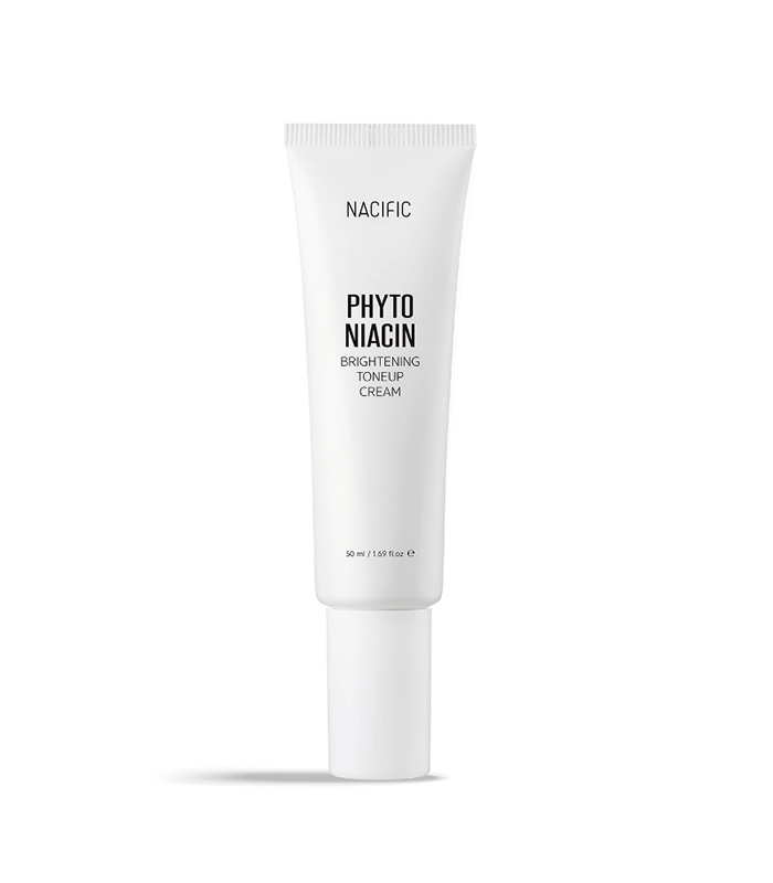 NACIFIC Phyto Niacin Brightening Essence bottle with fresh leaves and a lemon on a marble surface.